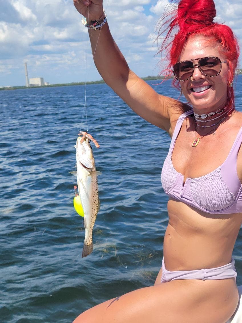 Fishaholic woman with a speckled trout on the water